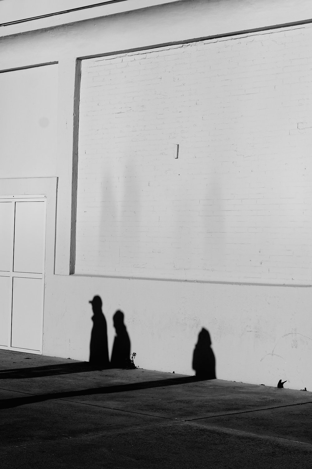 Three shadows on a white wall — Shadows